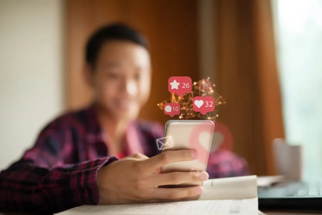 man holding his phone looking at social media